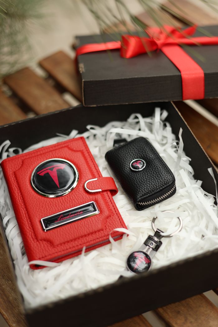 Elegant gift box featuring a red leather accessory and keychain wrapped with a ribbon.